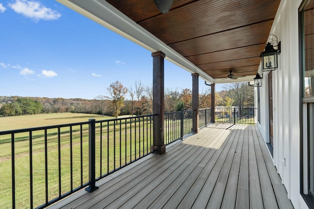 deck featuring a lawn, ceiling fan, and covered porch