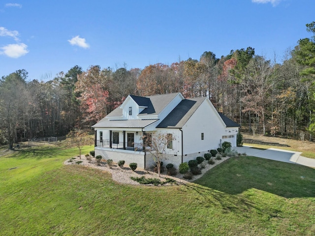 view of home's exterior with covered porch and a lawn