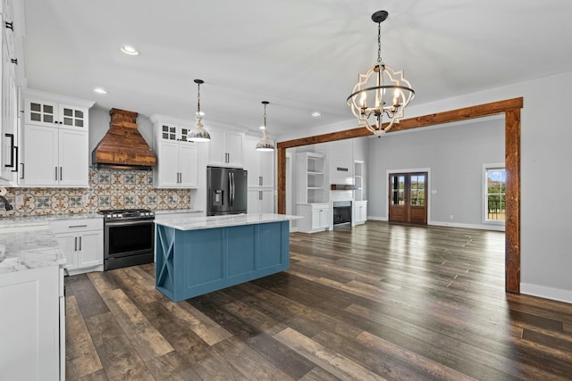 kitchen featuring white cabinets, stainless steel appliances, and custom range hood