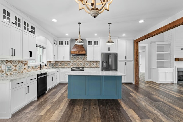 kitchen featuring decorative light fixtures, white cabinetry, custom range hood, and stainless steel appliances