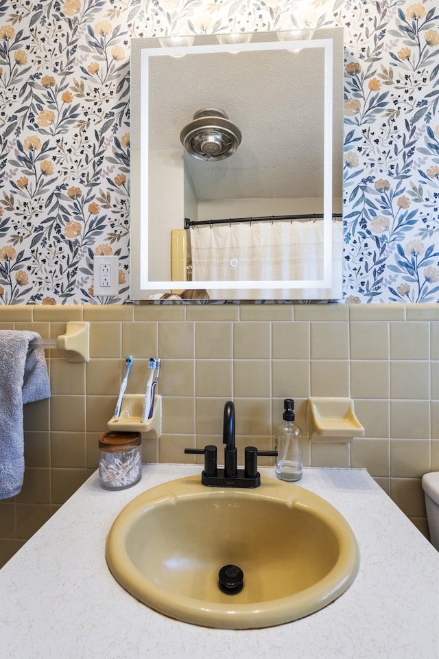 bathroom with tile walls and sink