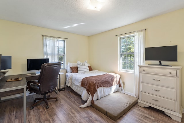 bedroom featuring a textured ceiling and dark hardwood / wood-style floors