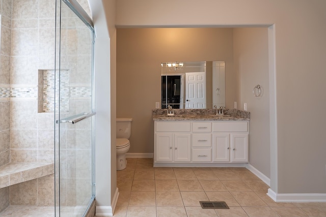 bathroom featuring a shower with door, tile patterned floors, vanity, and toilet