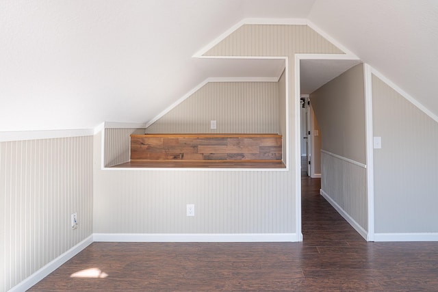 additional living space with dark wood-type flooring and vaulted ceiling