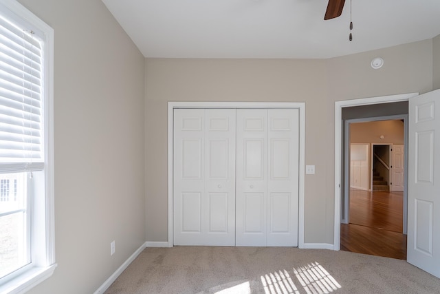 unfurnished bedroom featuring ceiling fan, a closet, and carpet floors