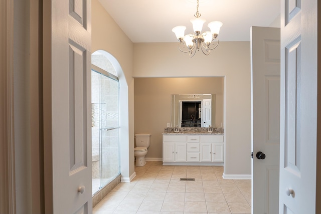 bathroom featuring toilet, tile patterned flooring, vanity, and a notable chandelier