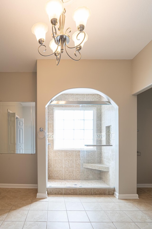 bathroom with tile patterned flooring and an inviting chandelier