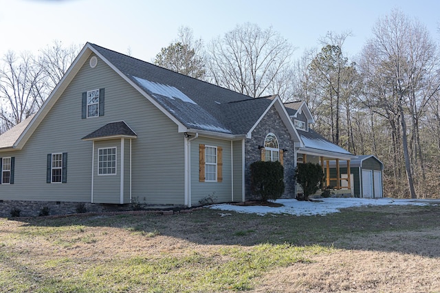 view of side of property featuring an outbuilding, a yard, and a garage