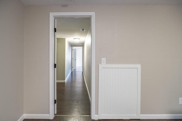 corridor with dark hardwood / wood-style flooring