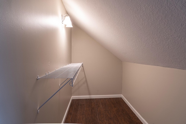 spacious closet with vaulted ceiling and dark hardwood / wood-style floors