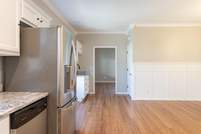 kitchen featuring light hardwood / wood-style floors, light stone countertops, stainless steel appliances, ornamental molding, and white cabinets