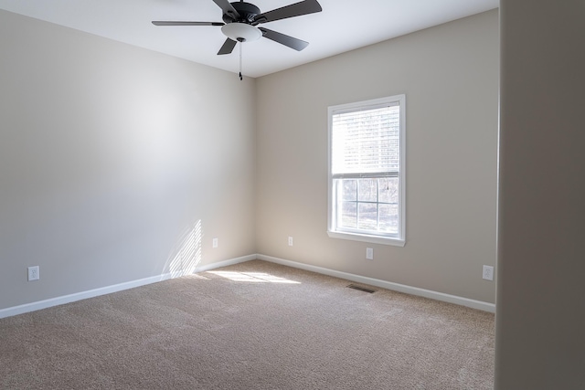 spare room with ceiling fan and carpet