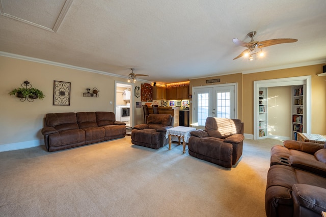 carpeted living room with a textured ceiling, ceiling fan, crown molding, and french doors