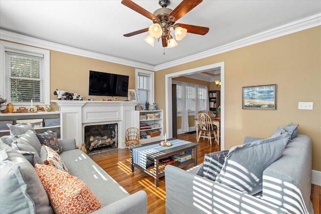 living room with hardwood / wood-style flooring, crown molding, and ceiling fan