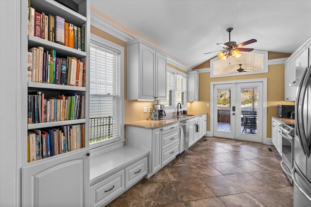 kitchen featuring lofted ceiling, sink, white cabinets, stainless steel appliances, and french doors