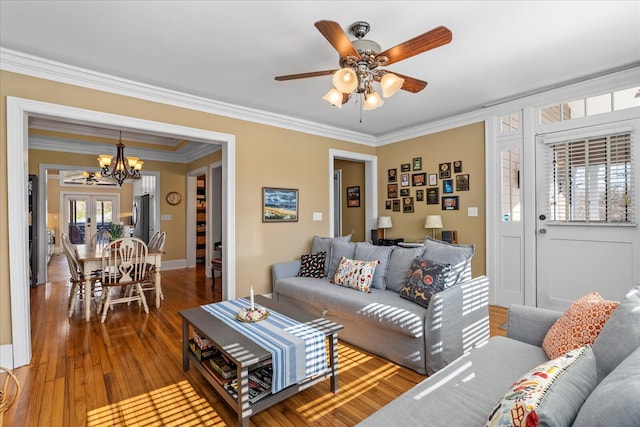 living room featuring crown molding, ceiling fan with notable chandelier, hardwood / wood-style floors, and french doors