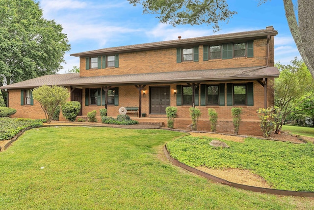 view of front of property with covered porch, a front lawn, and brick siding