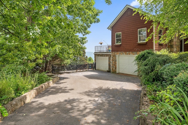 212 N Palisades Dr, Signal Mountain, TN 37377 - view of home's exterior featuring asphalt driveway, stone siding, and an attached garage