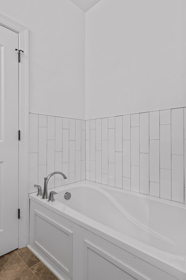 bathroom with a tub to relax in and tile patterned flooring