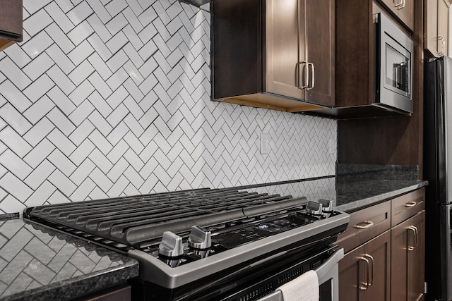 kitchen with tasteful backsplash, dark brown cabinets, dark stone counters, and stainless steel appliances