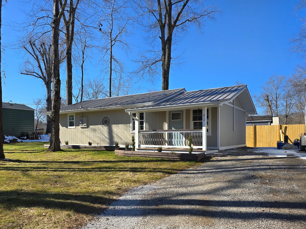 single story home featuring covered porch and a front yard