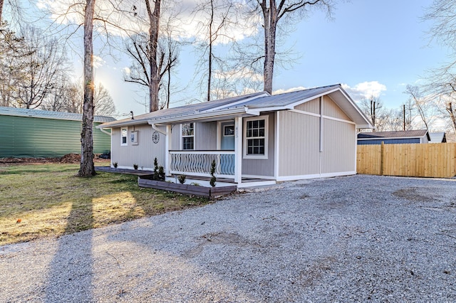 ranch-style home featuring covered porch and a front yard