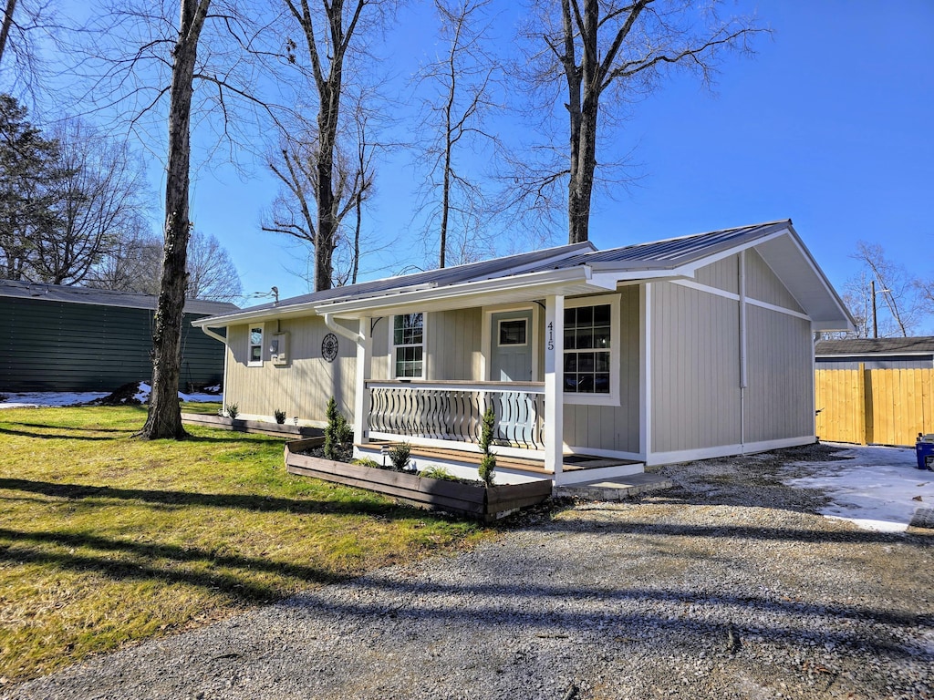 ranch-style home with covered porch and a front lawn