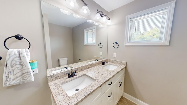 bathroom with plenty of natural light, vanity, and toilet