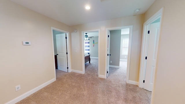 hallway featuring light colored carpet