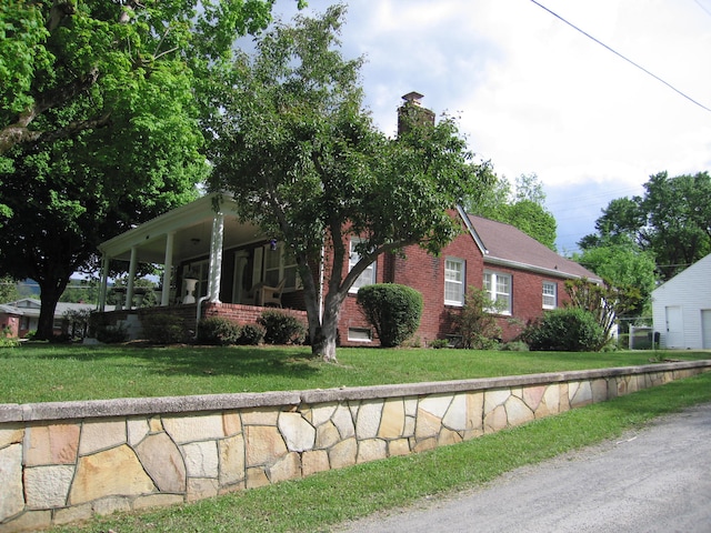 view of front of house with covered porch and a front lawn