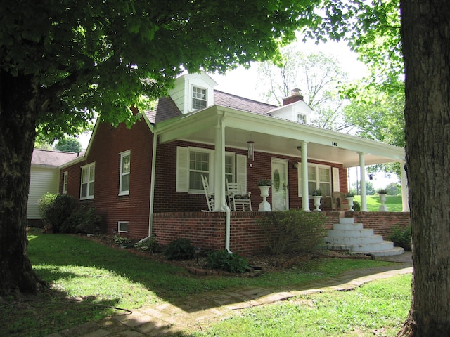 view of front of home featuring covered porch and a front yard