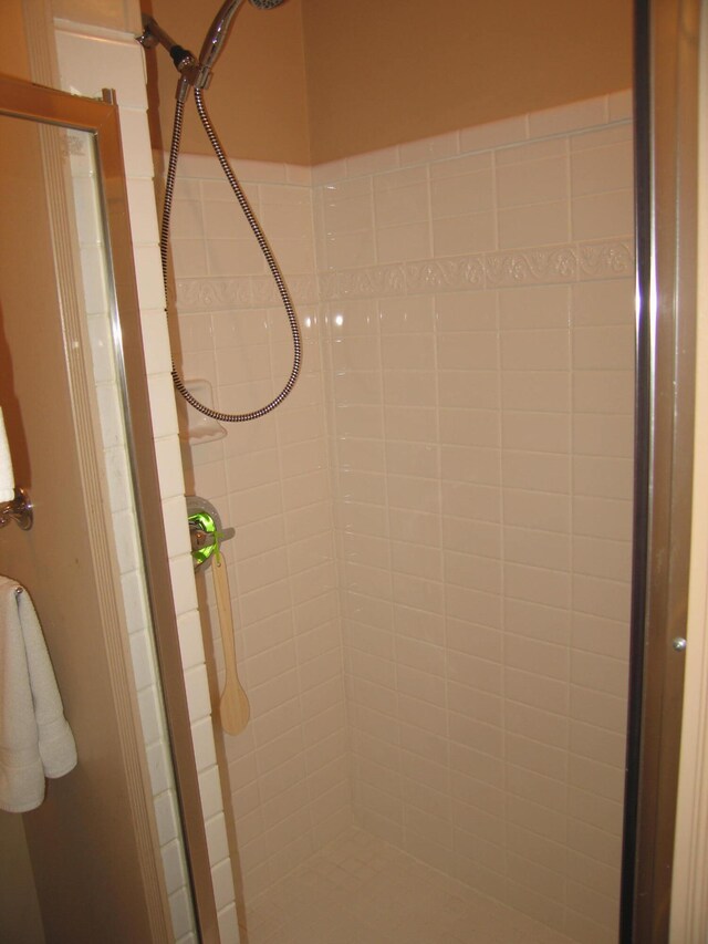 interior details featuring a tile shower