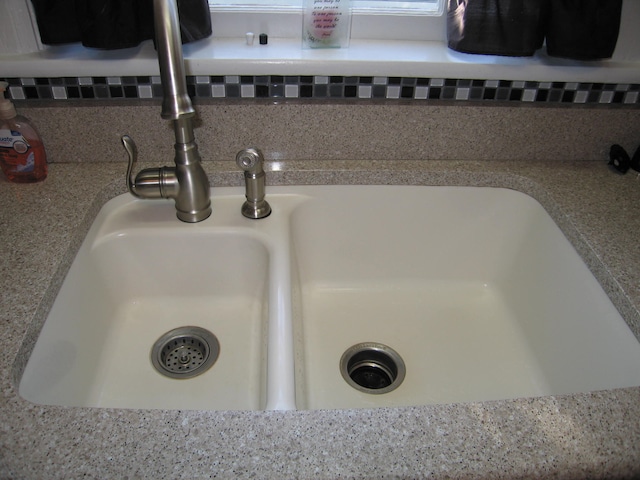 room details featuring decorative backsplash and sink