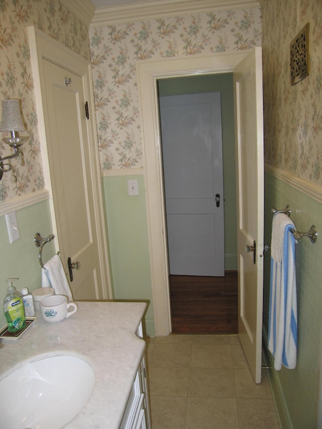 bathroom featuring hardwood / wood-style floors, vanity, and ornamental molding