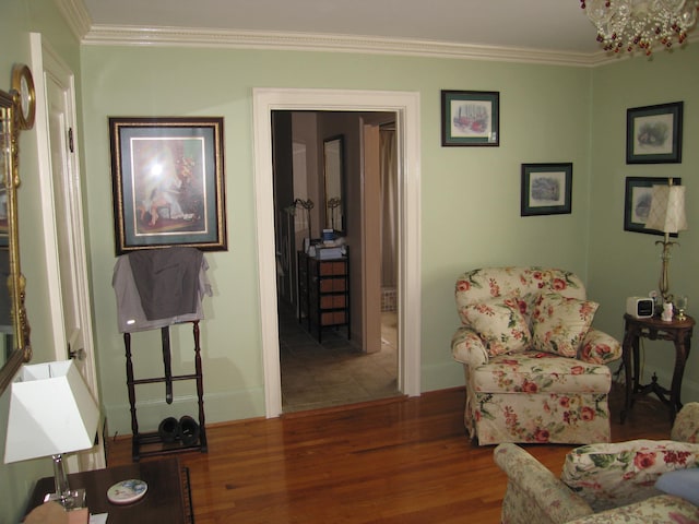 sitting room with a chandelier, ornamental molding, and hardwood / wood-style flooring