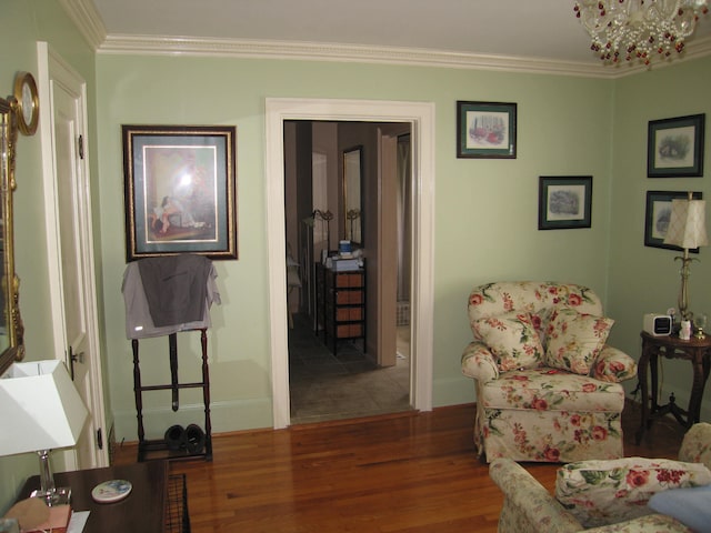 sitting room with hardwood / wood-style flooring, a notable chandelier, and crown molding