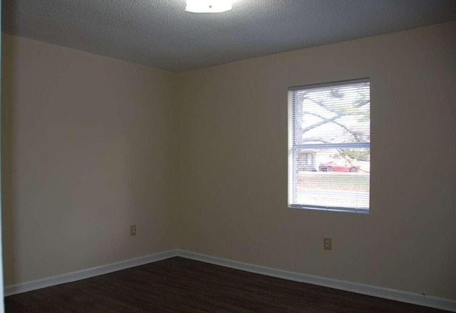 unfurnished room with a textured ceiling, dark hardwood / wood-style flooring, and plenty of natural light