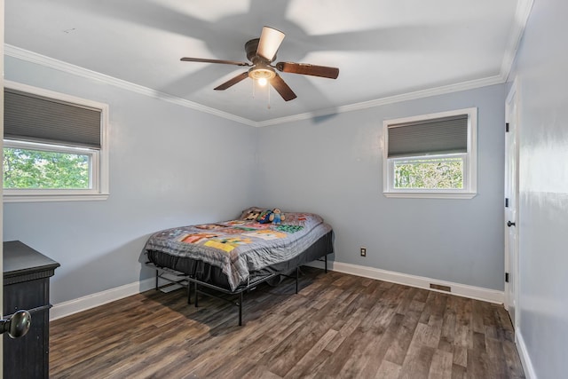 bedroom featuring wood finished floors, ornamental molding, baseboards, and multiple windows