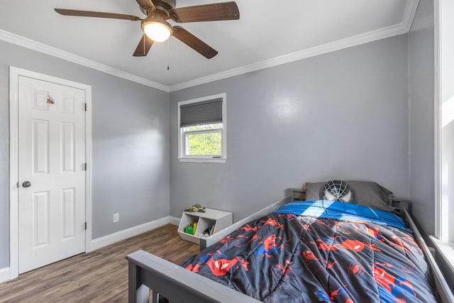 bedroom featuring wood finished floors, a ceiling fan, baseboards, and ornamental molding