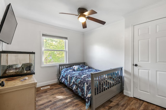 bedroom featuring visible vents, baseboards, a ceiling fan, wood finished floors, and ornamental molding