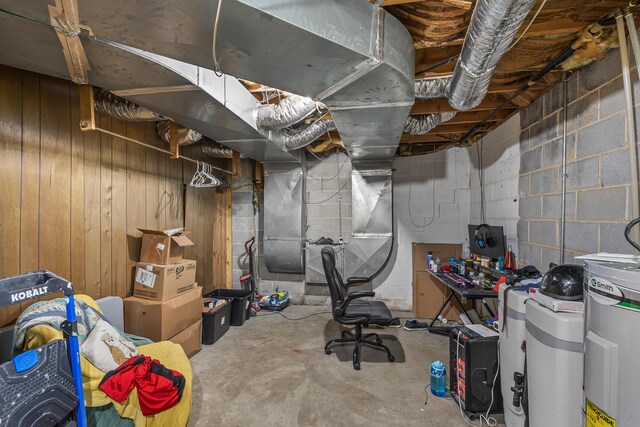 unfinished basement featuring concrete block wall and wooden walls