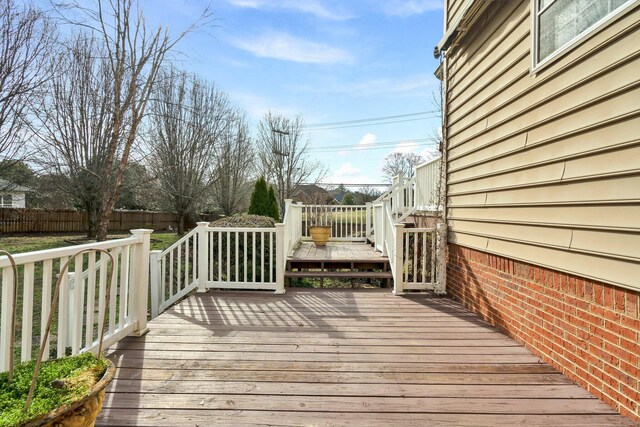 wooden terrace featuring fence