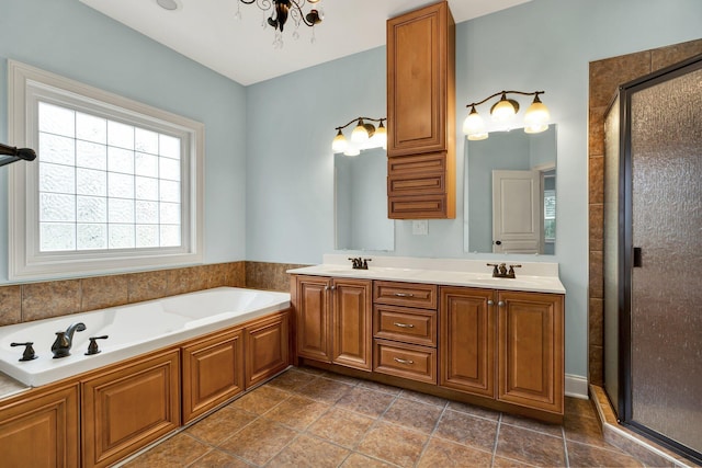 full bath with a sink, double vanity, a bath, and a shower stall