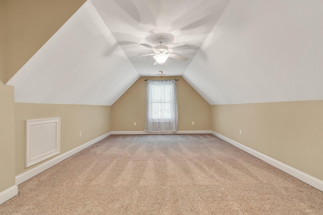 additional living space featuring vaulted ceiling, baseboards, and light carpet