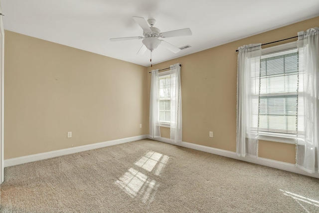 empty room with visible vents, a ceiling fan, baseboards, and carpet floors