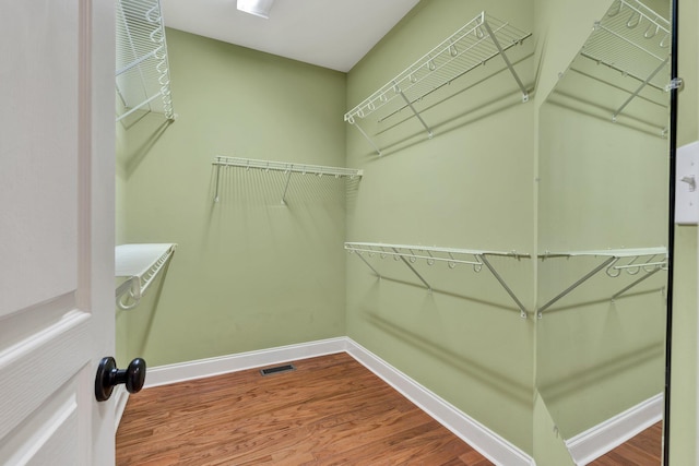 walk in closet with wood finished floors