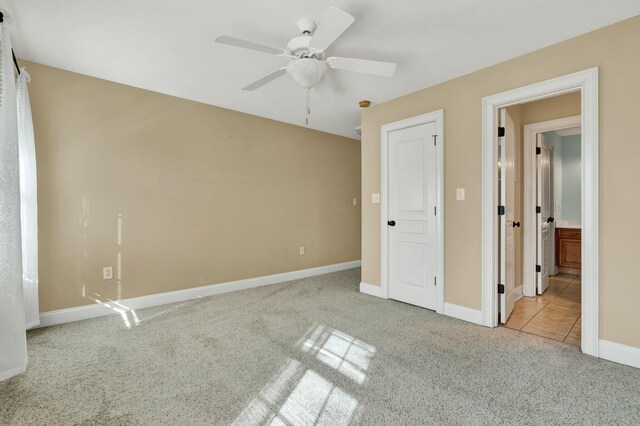 unfurnished bedroom featuring baseboards, carpet, and a ceiling fan