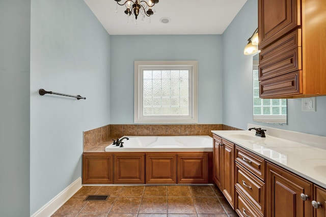 full bath featuring visible vents, a garden tub, a sink, double vanity, and baseboards