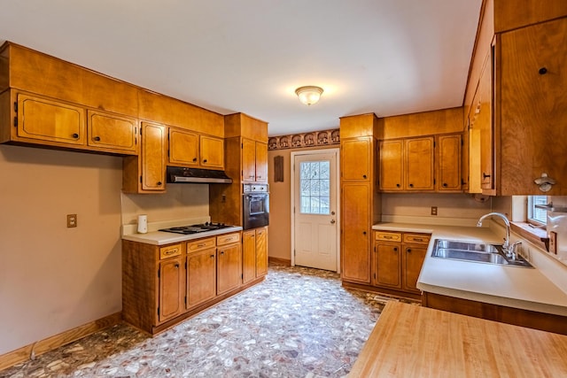 kitchen with white gas stovetop, sink, and black oven