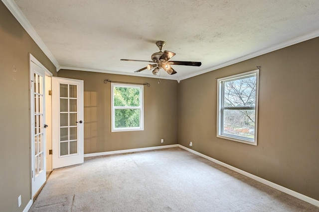 carpeted empty room featuring ceiling fan, crown molding, french doors, and a textured ceiling